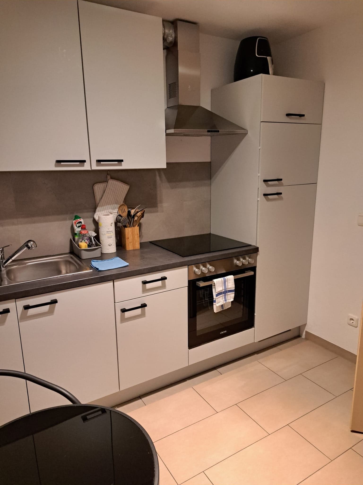Küche der Wohnung A mit Kochfeld, Backofen, Dunstabzugshaube und Kühl-Gefrier-Kombination