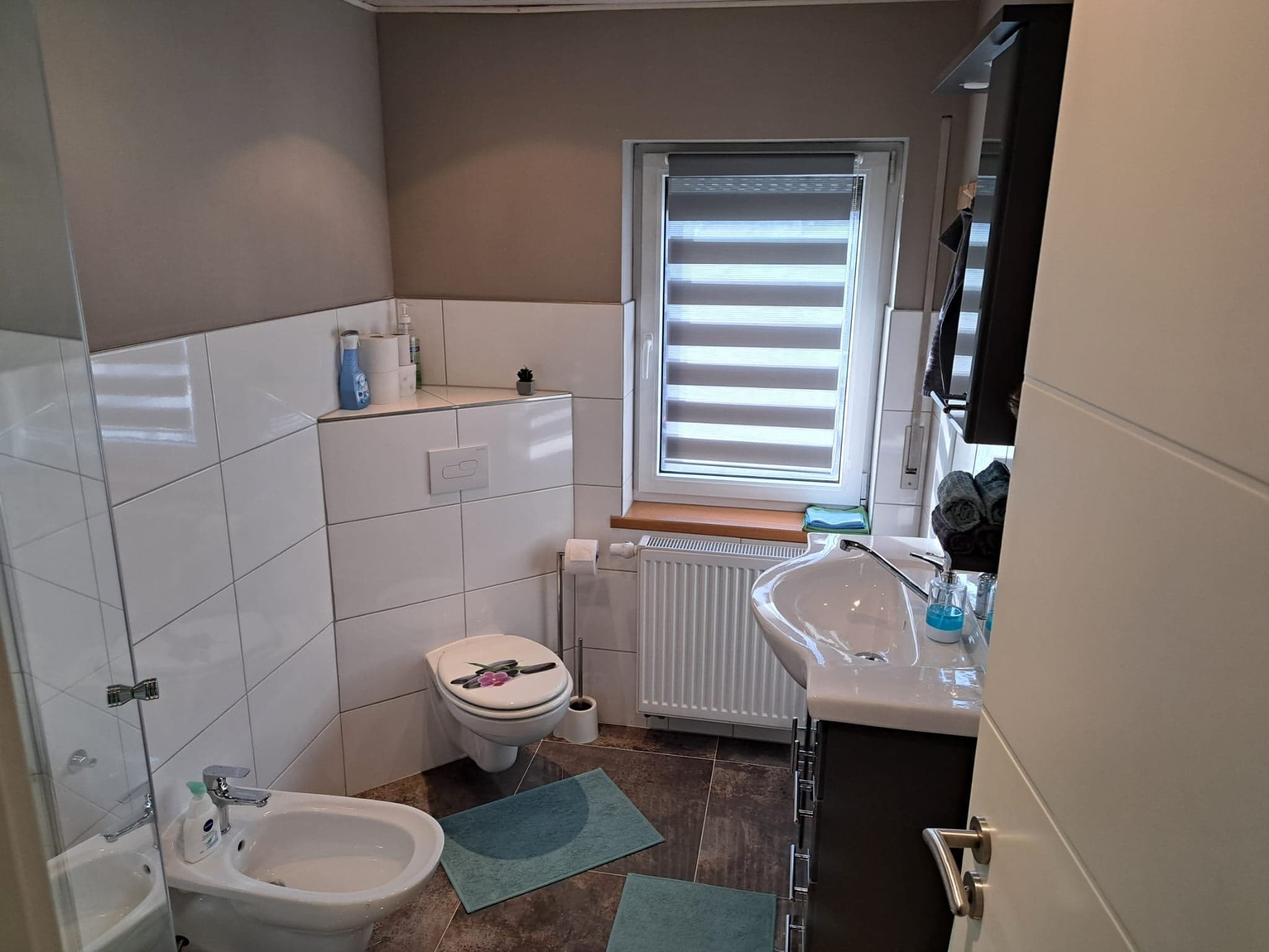 Badezimmer der Wohnung B mit Dusche, Waschbecken, WC und Bidet