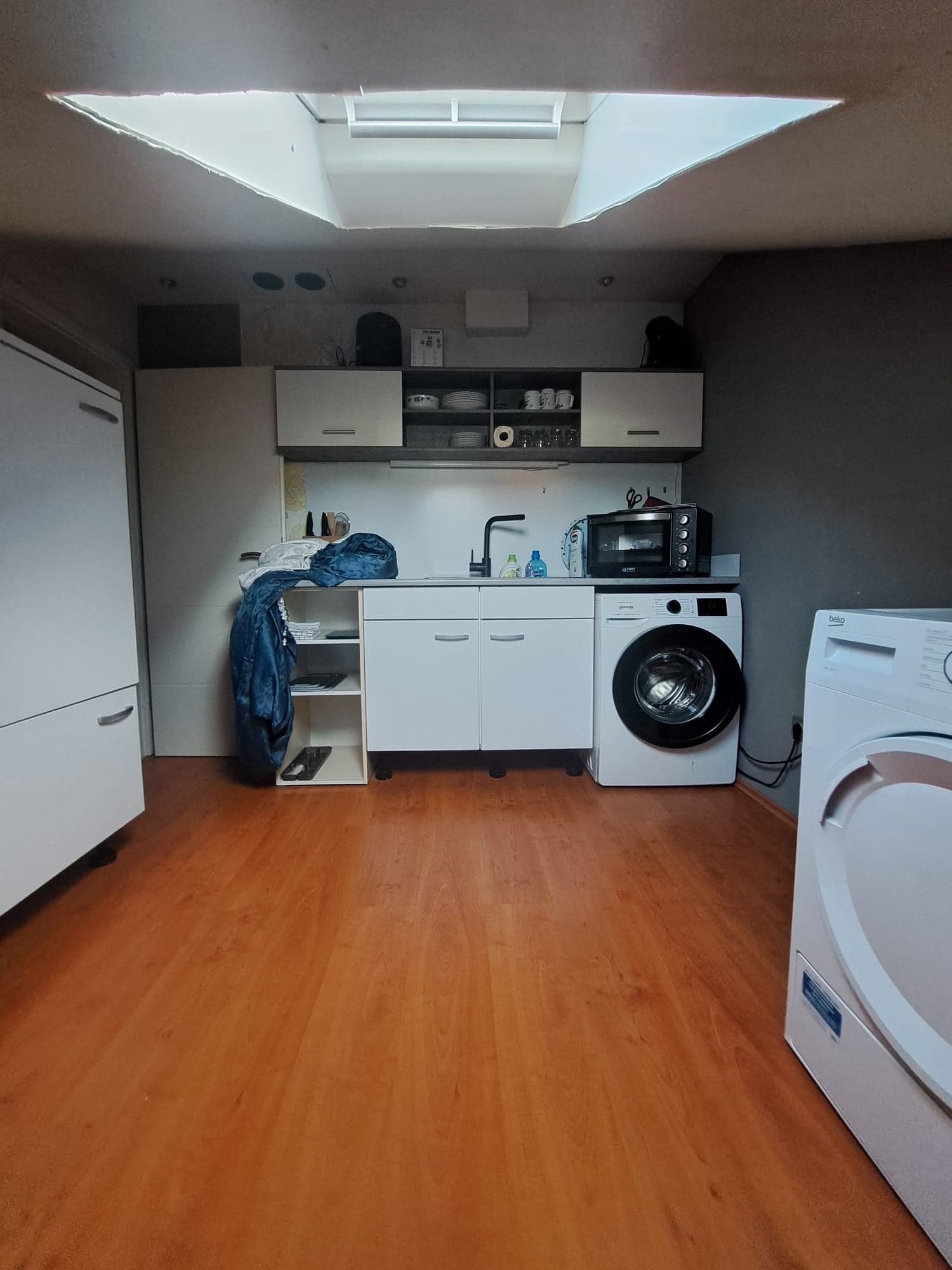 Küche der Wohnung B mit Küchenzeile, Dachfenster sowie Waschmaschine und Trockner