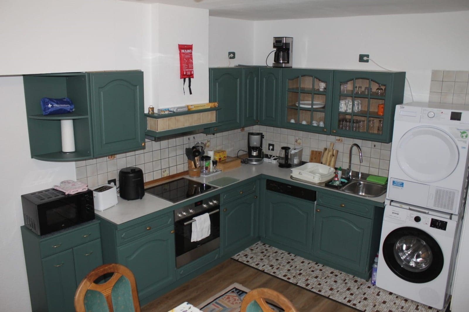 Grüne Landhausküche der Wohnung C mit Backofen, Geschirrspüler, Waschmaschine und Trockner